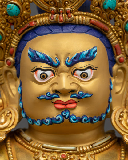 Detailed close up face Dzambhala wrathful expression with five-jeweled crown and intricately carved jewelry
