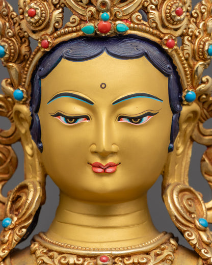 Detailed close up face Green Tara Statue showing radiant gold face with jeweled crown
