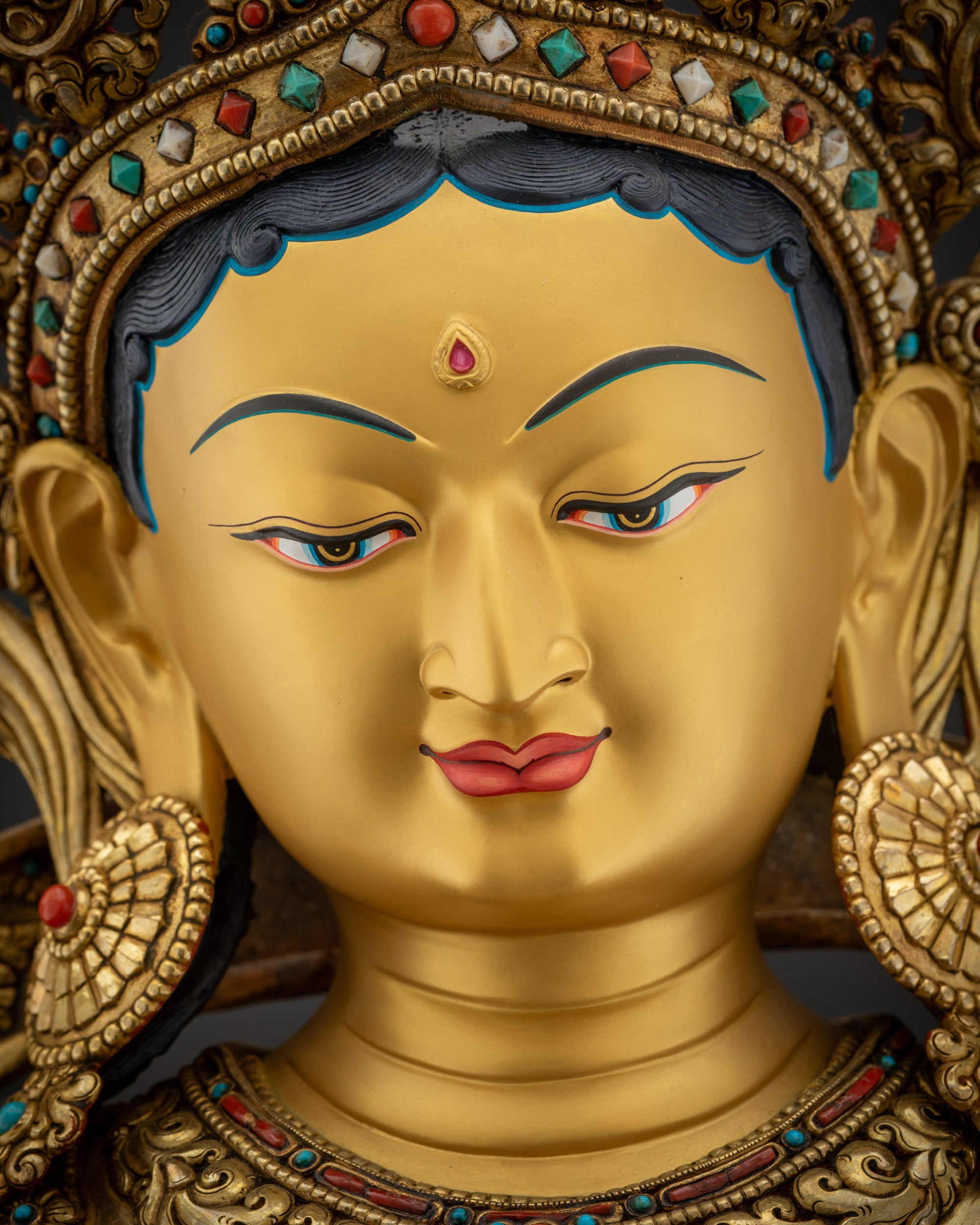 Detailed close up face Green Tara serene face gold-gilded crown Nepalese artisan work
