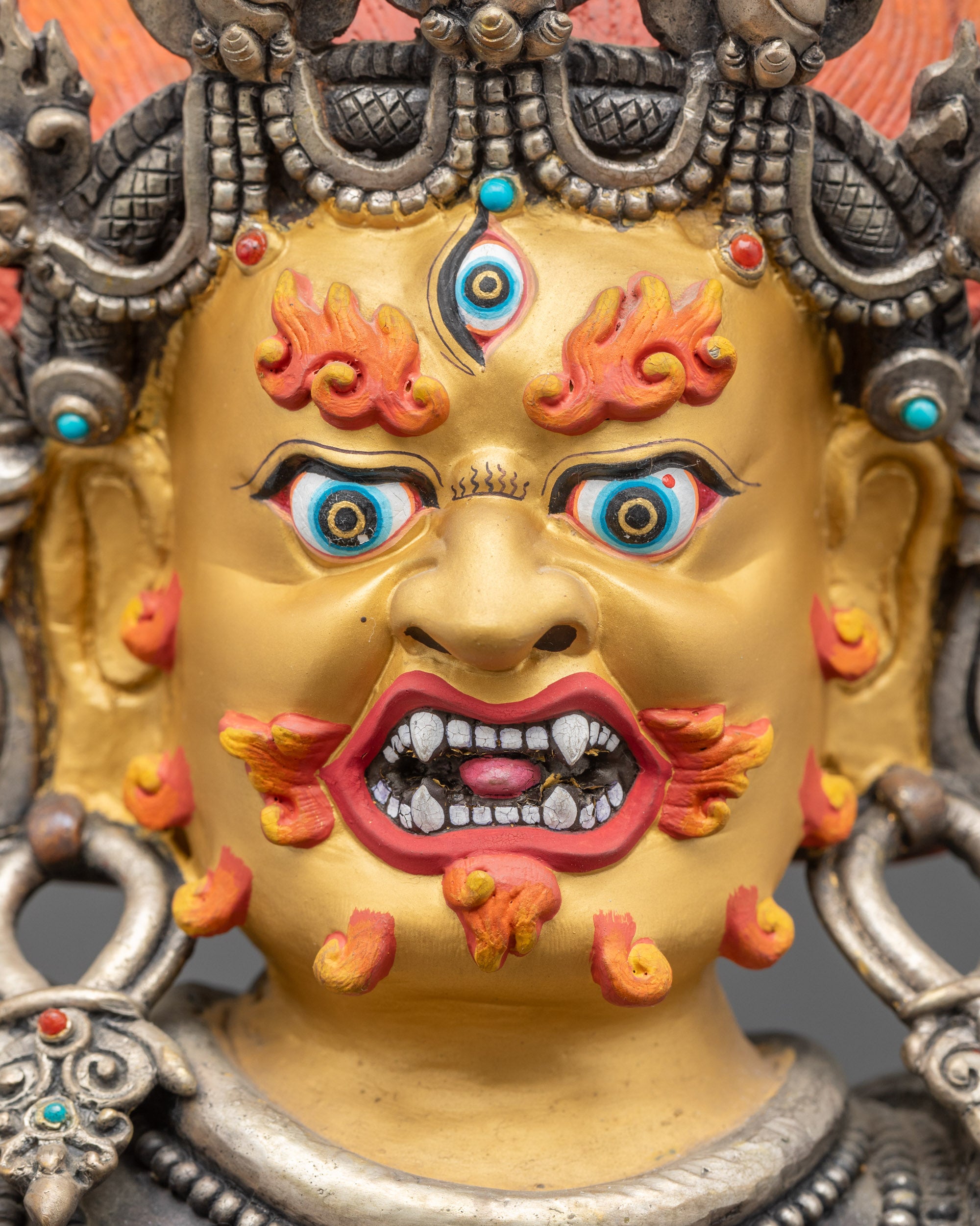Detailed close up face Oxidized Black Dzambhala gold-gilded face with third eye close up
