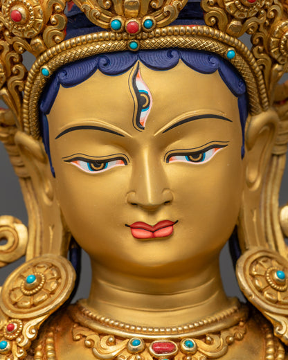 Detailed close up face White Tara Statue with tranquil gold-gilded expression
