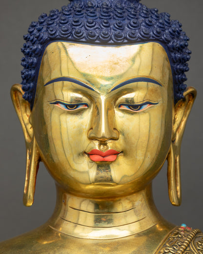 Detailed close up face of Buddha Shakyamuni Statue with serene gaze and gold fire-gilded finish
