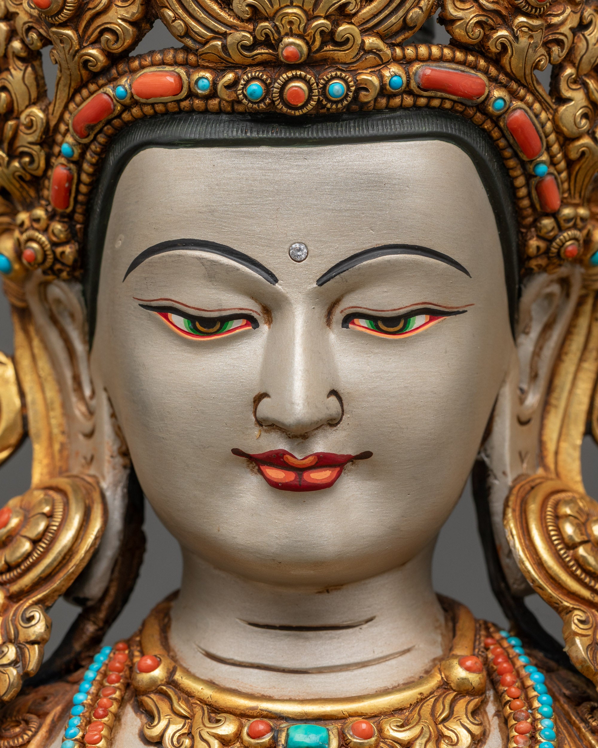 Detailed close up face of Chenrezig statue showing serene compassionate expression
