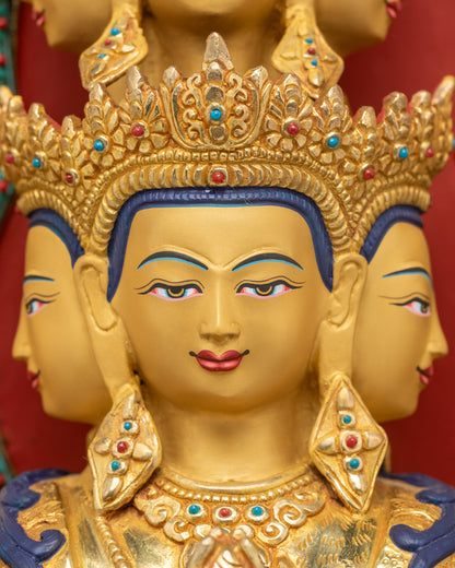 Detailed close up face of Chenrezig statue with eleven gold-gilded crowns and serene expression
