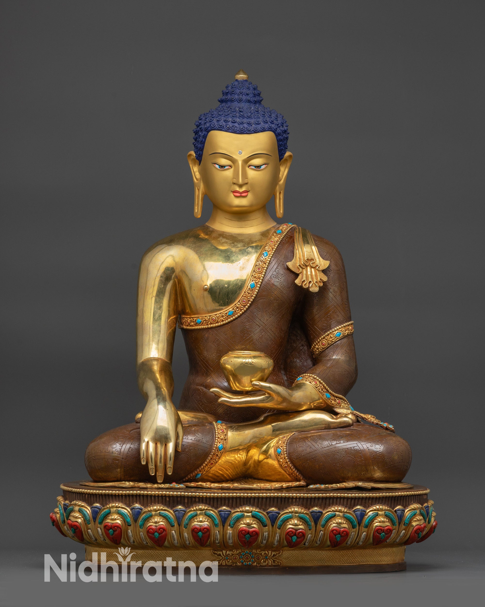 Detailed close up face of Gautama Buddha with gold-gilded finish and serene expression
