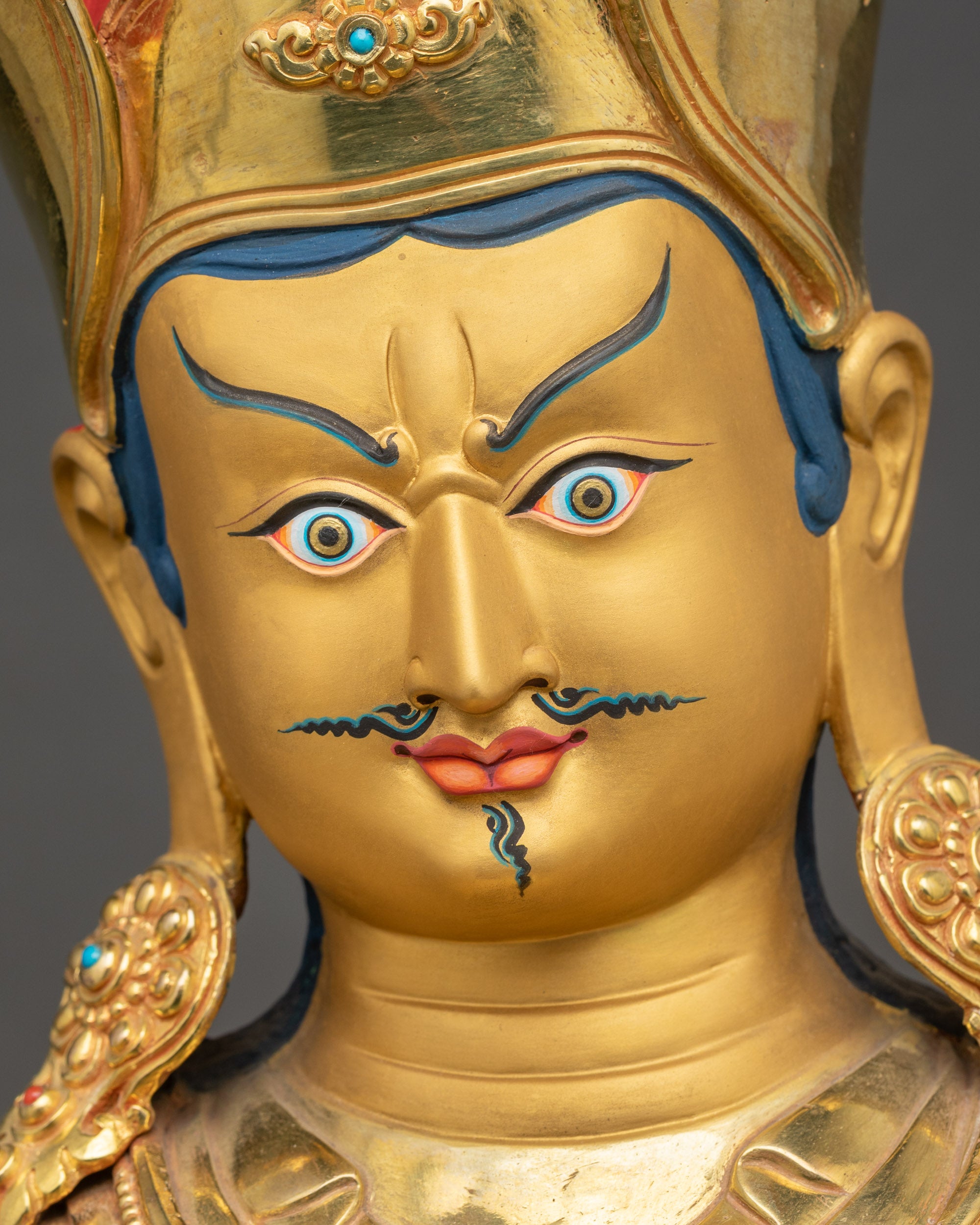 Detailed close up face of Guru Rinpoche Statue with expressive eyes and dignified mustache