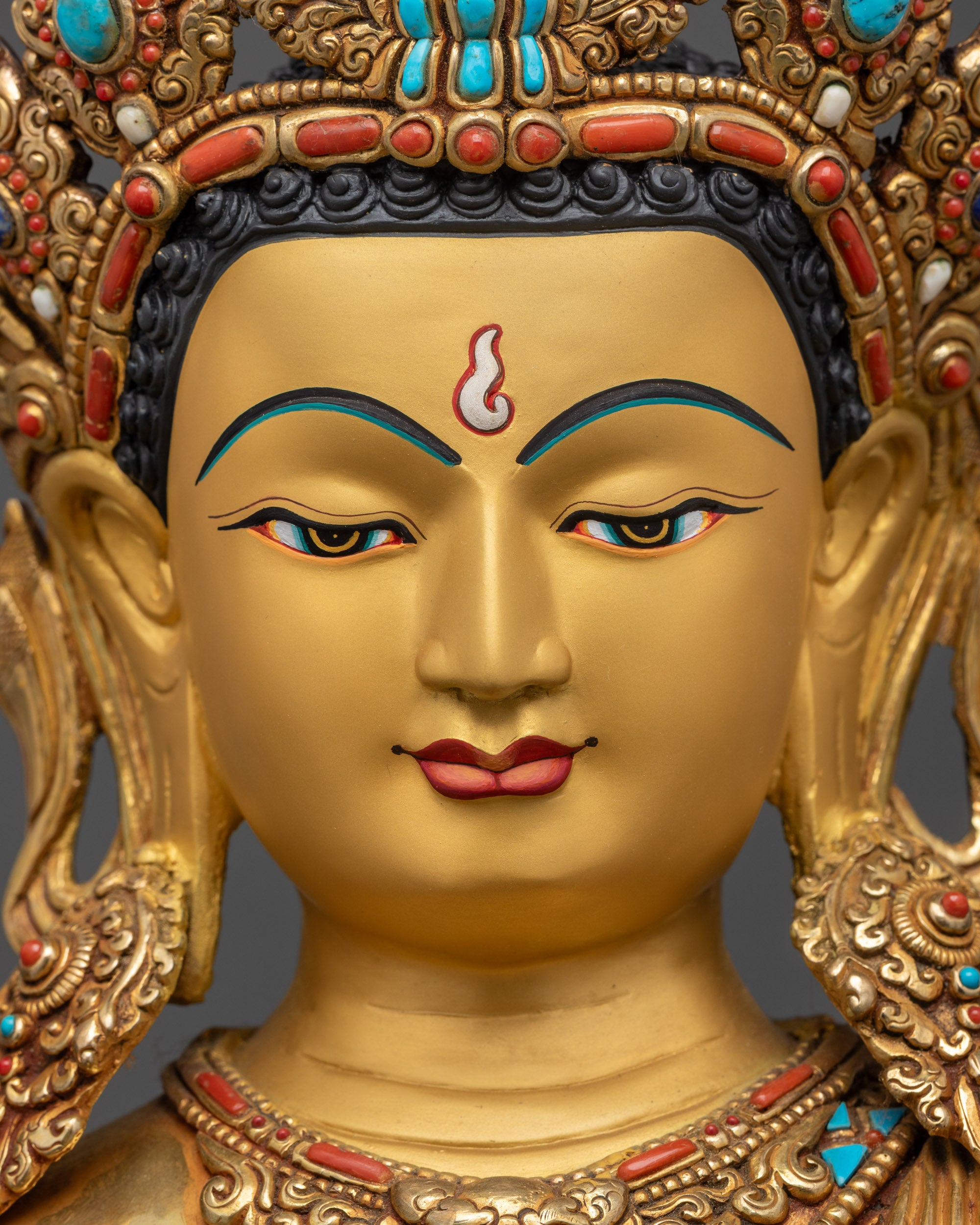 Detailed close up face of Maitreya Buddha with serene expression and gold gilding