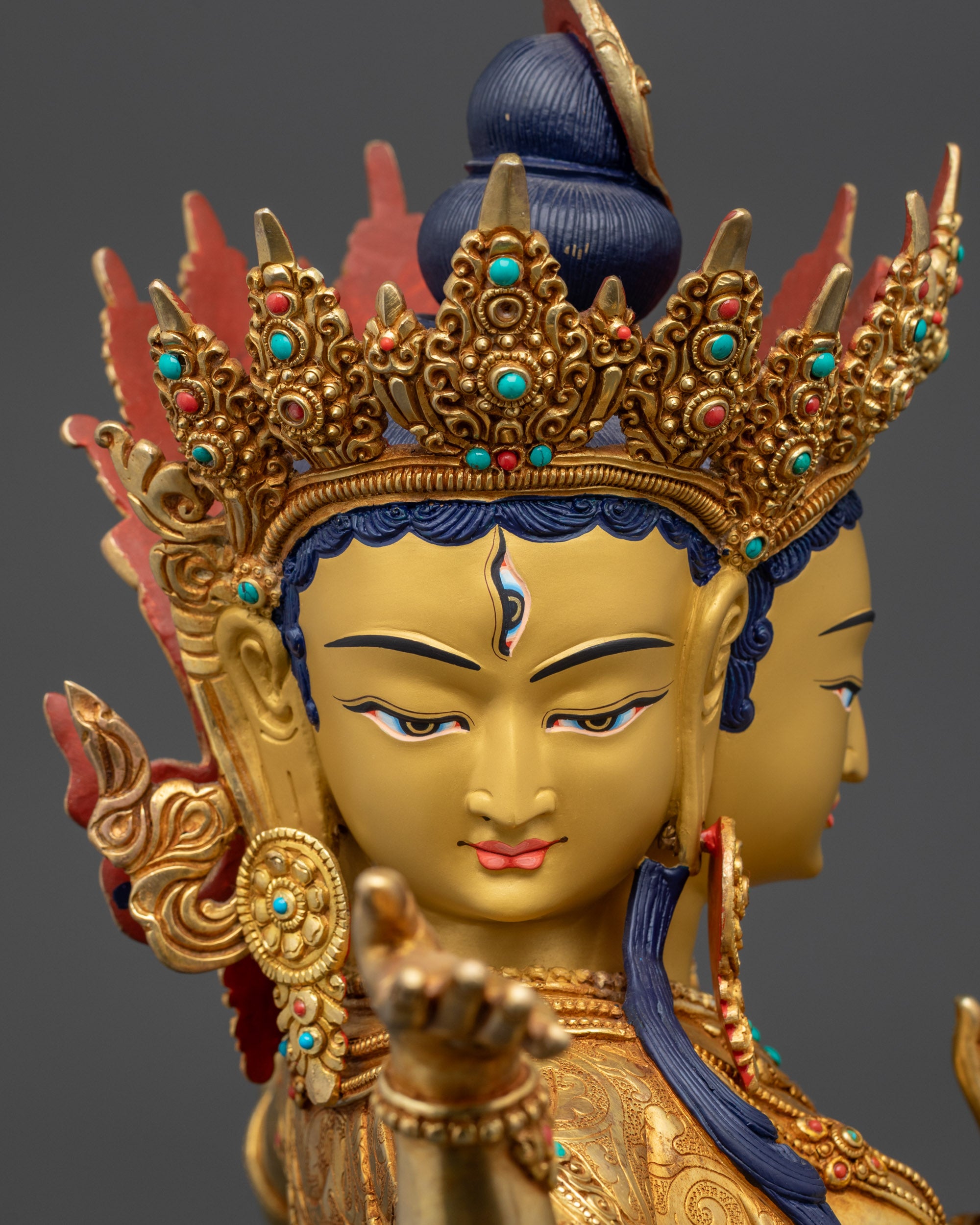 Detailed close up face of Namgyalma Ushnishavijaya statue with gold-gilded crown