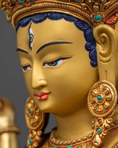 Detailed close up face of Namgyalma statue showing three expressive gold-gilded faces