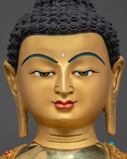 Detailed close up face of Shakyamuni Buddha statue with serene expression and gold gilding
