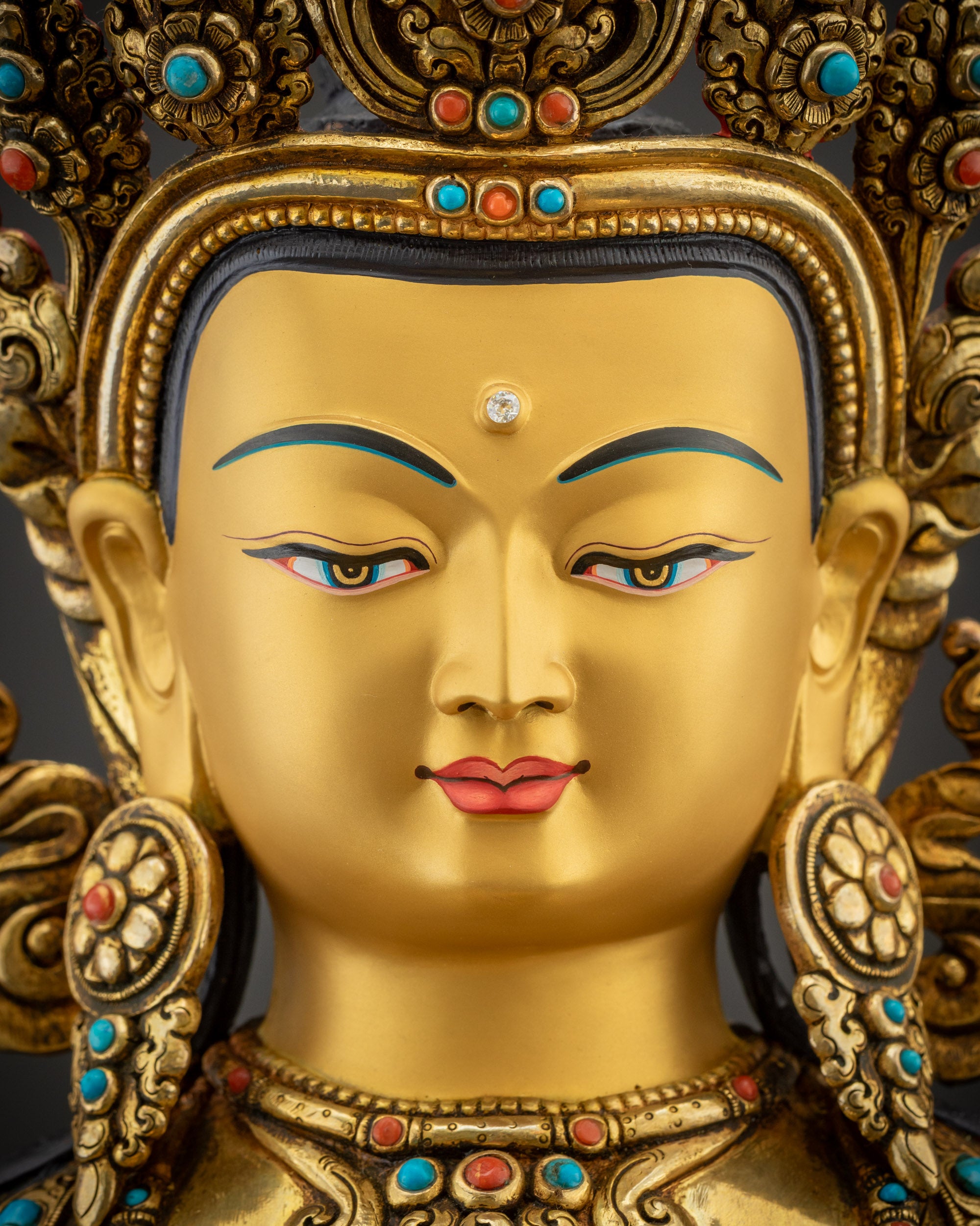 Detailed close up face of Vajrasattva statue with gold fire gilded serene expression