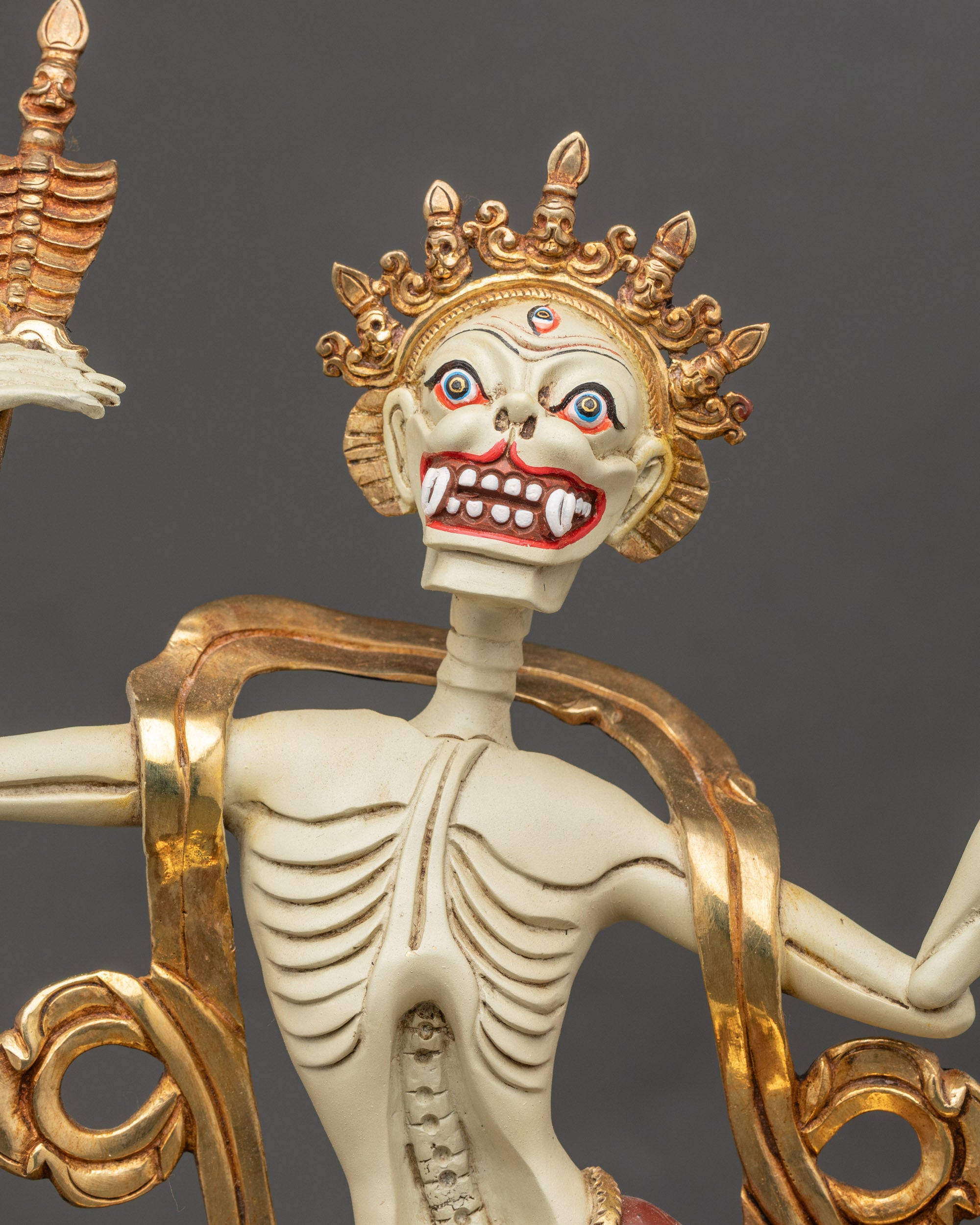 Detailed close up face of male and female Citipati with gold-plated skull crowns
