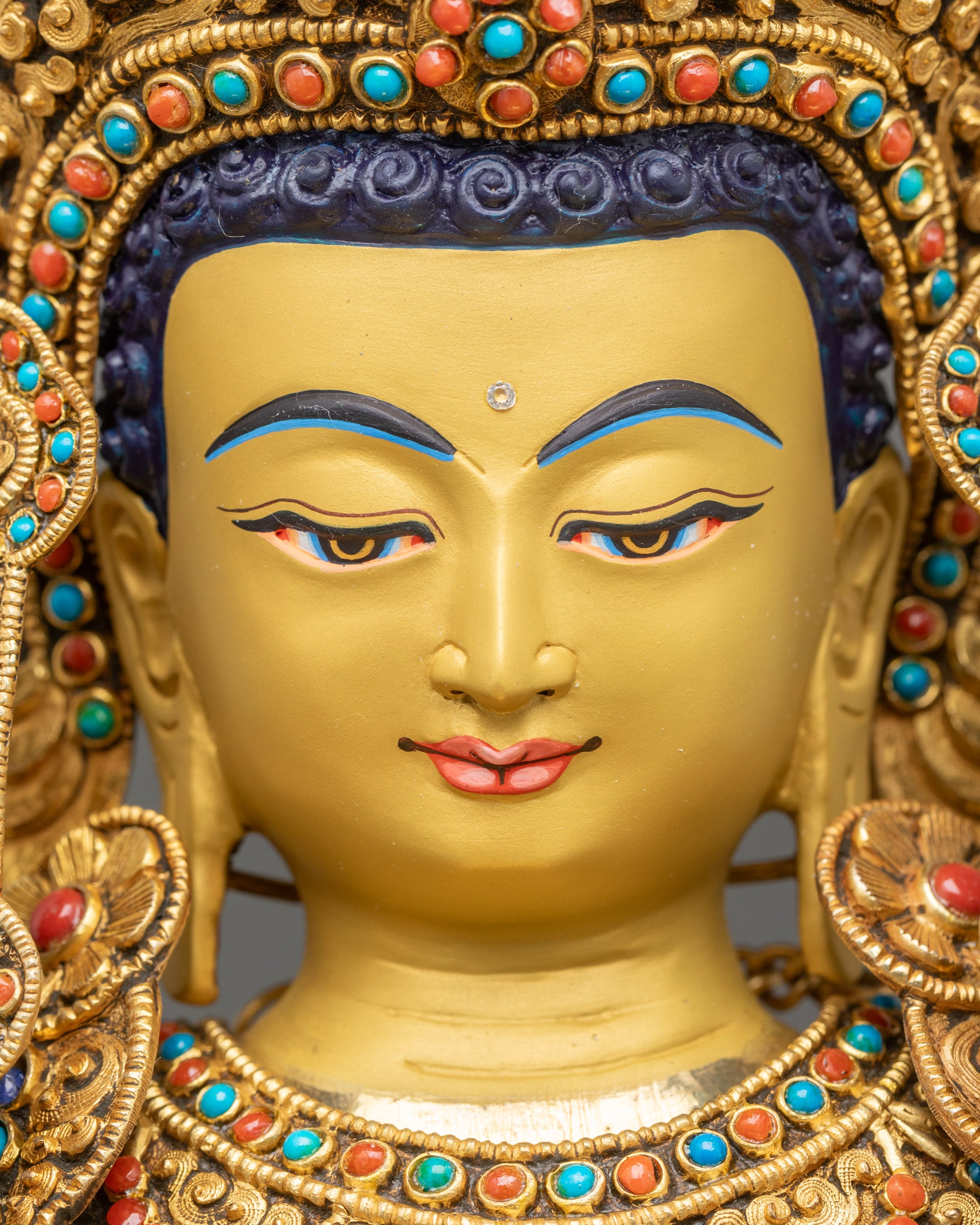 Detailed close up face of serene gold-gilded Jowo Shakyamuni Buddha with calm expression
