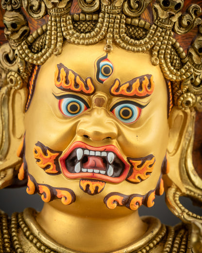Detailed close up face showing piercing eyes, mustache, and gold-gilded face
