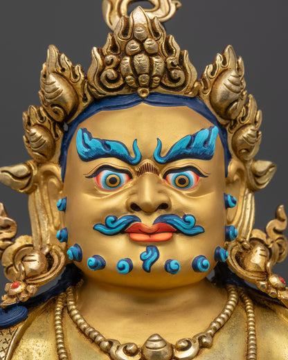 Detailed close up gold-gilded face of Dzambhala Statue with wrathful expression