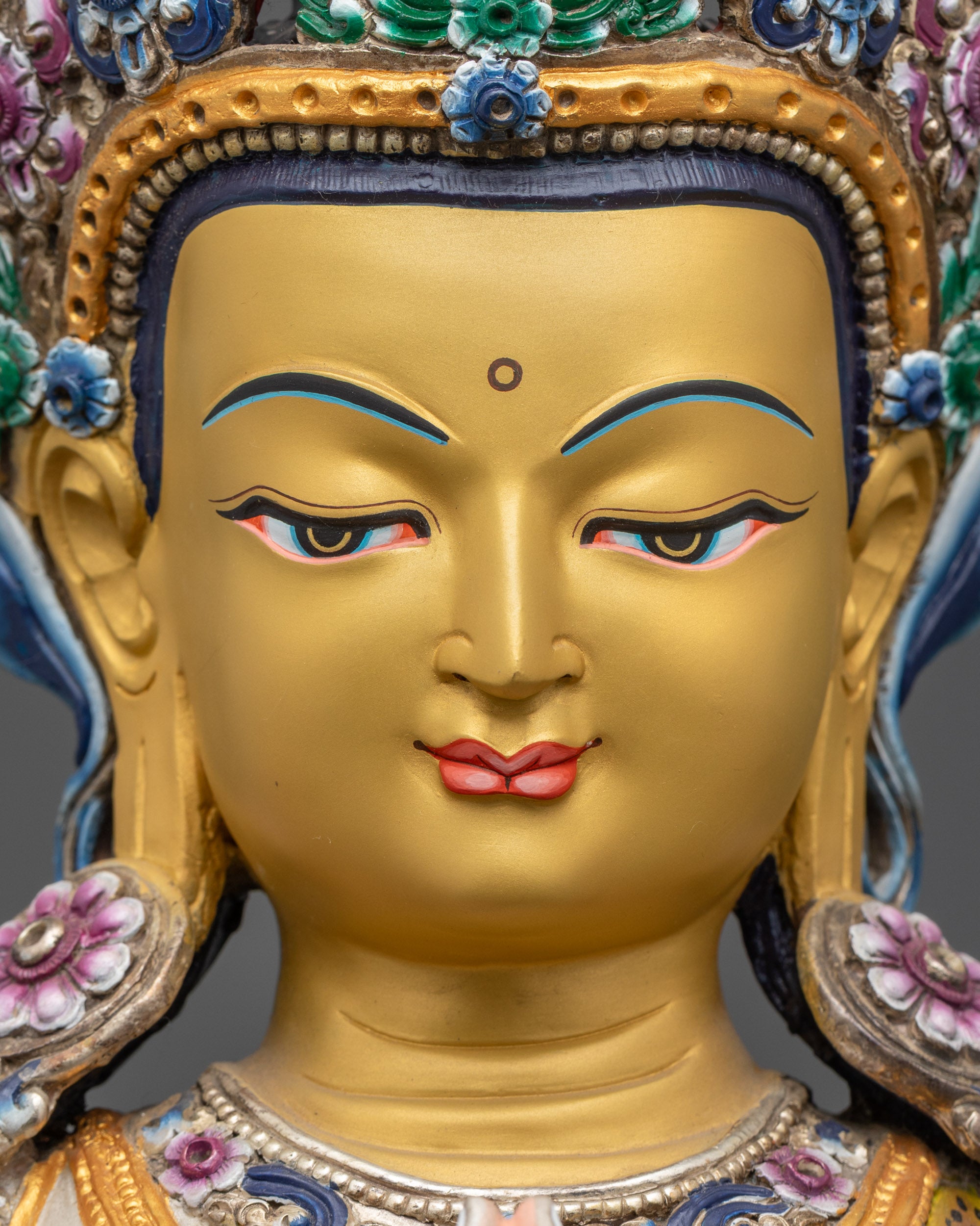 Detailed close up of Chenrezig gold-gilded face and crystal rosary in hand