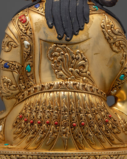Detailed close up of Guru Rinpoche statue showing intricate robe patterns and motifs
