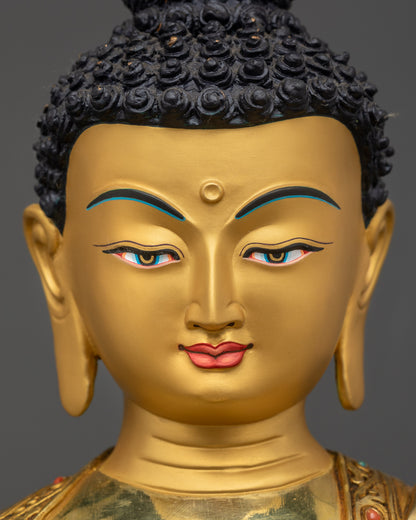 Detailed close up of Shakyamuni Buddha face with serene expression and gold gilding
