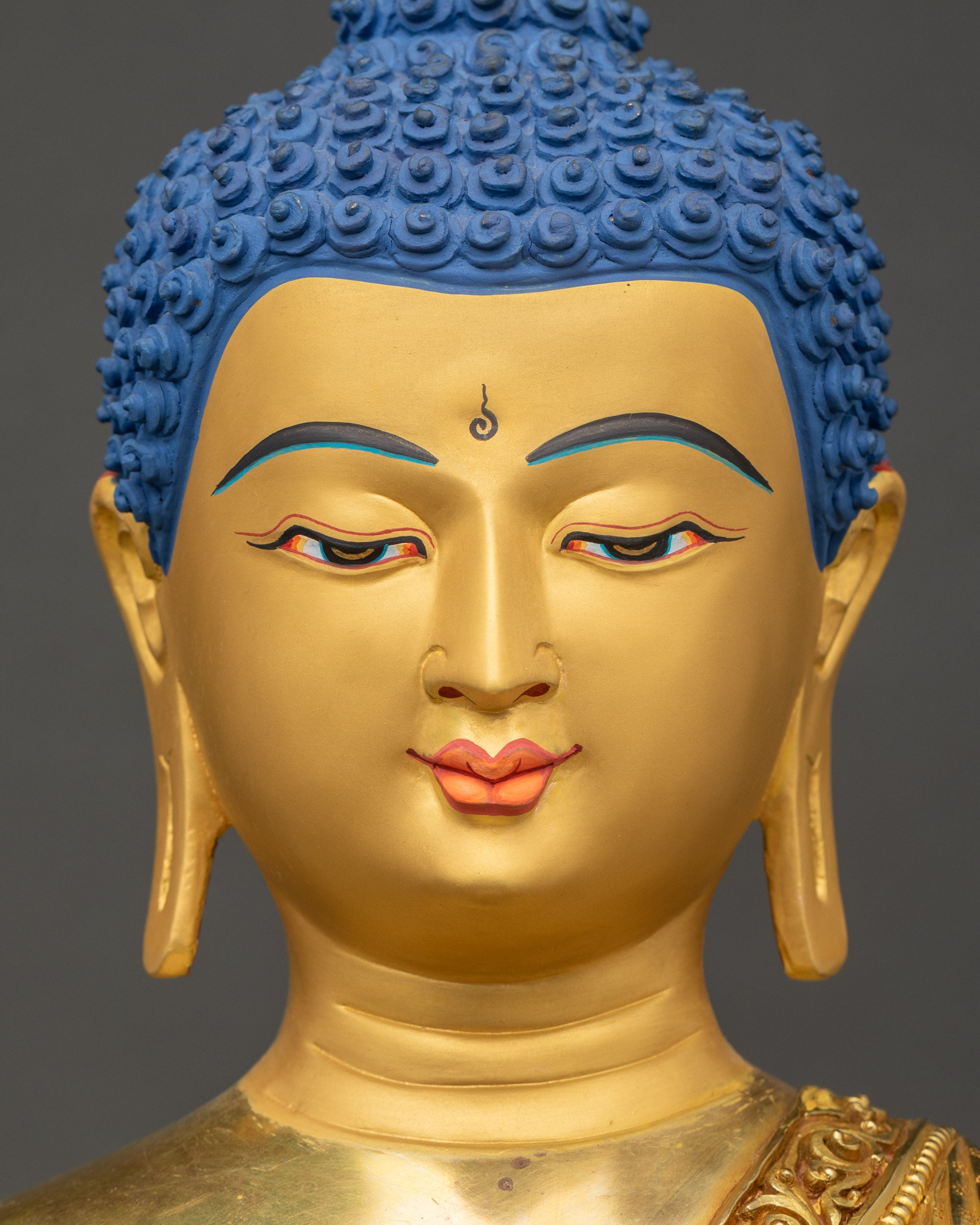 Detailed close up of Medicine Buddha gold face with serene expression