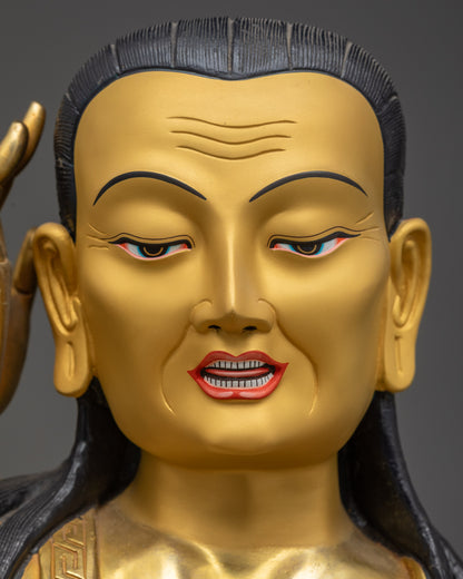 Detailed close up of Milarepa gold-gilded face with semi-wrathful listening expression
