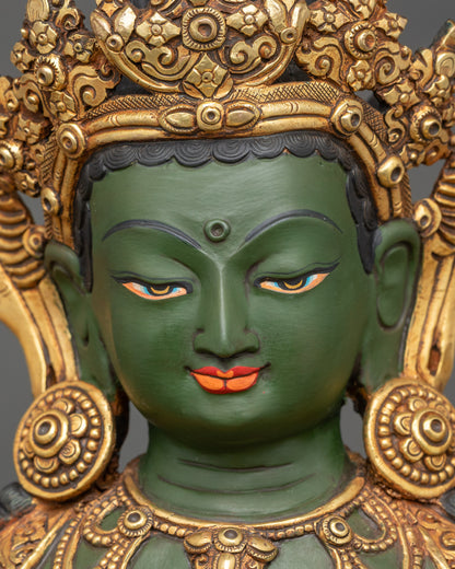 Detailed face of Green Tara statue showing serene expression and gold gilded features