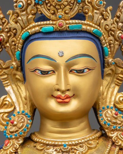 Detailed face of Maitreya Buddha statue with serene expression and gold-painted features