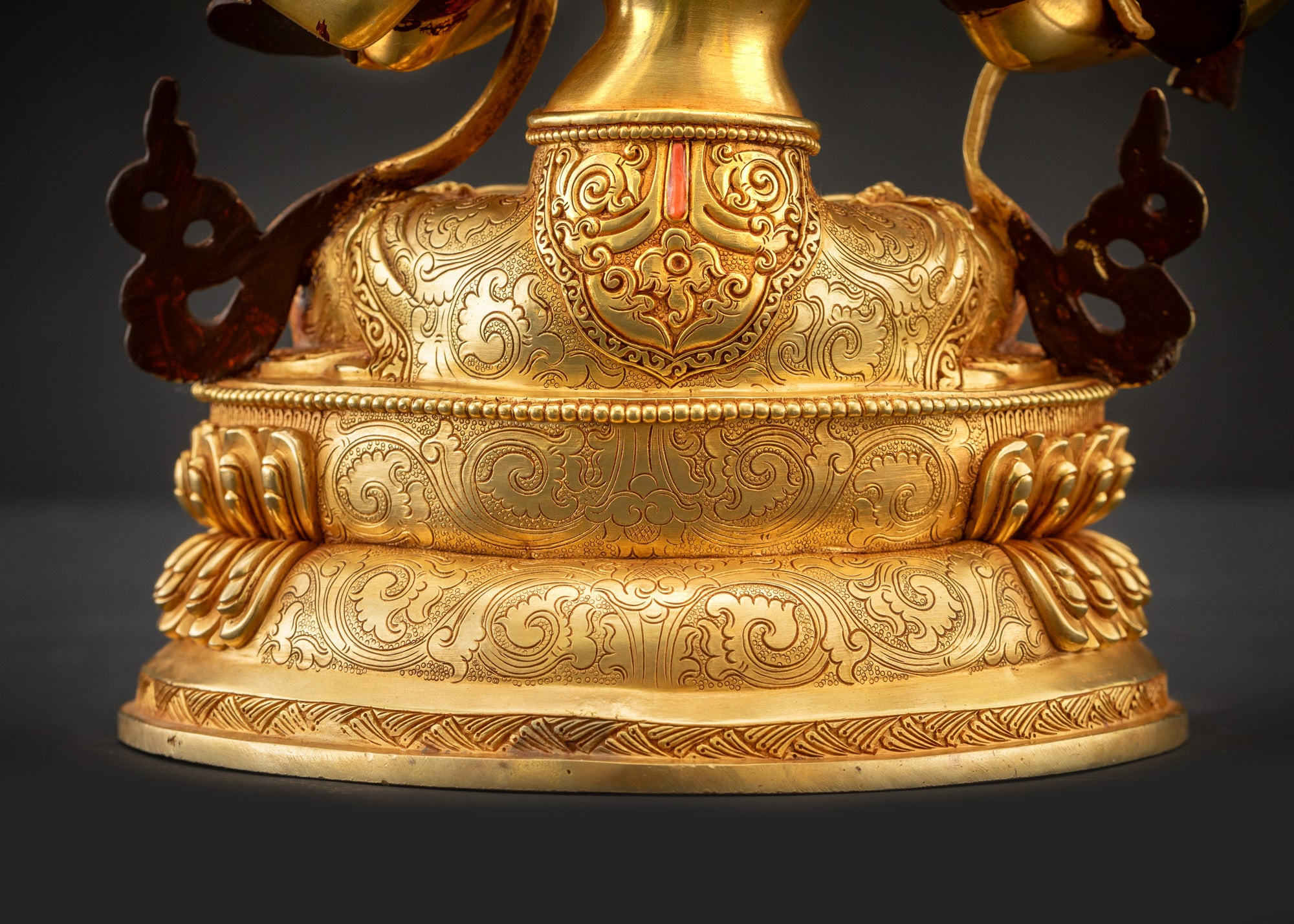 Detailed landscape back view of statue seated on lotus showing carved robe folds and jewelry
