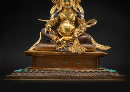 Detailed landscape front shot Dzambhala statue on lotus seat with halo and gemstones