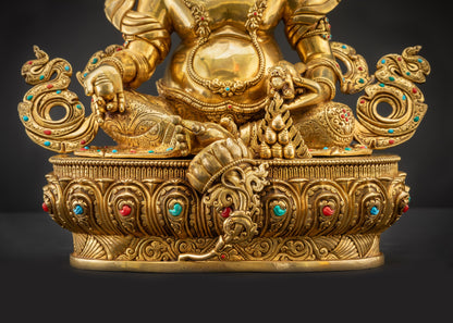 Detailed landscape front view of statue seated on lotus showing gold-gilded features
