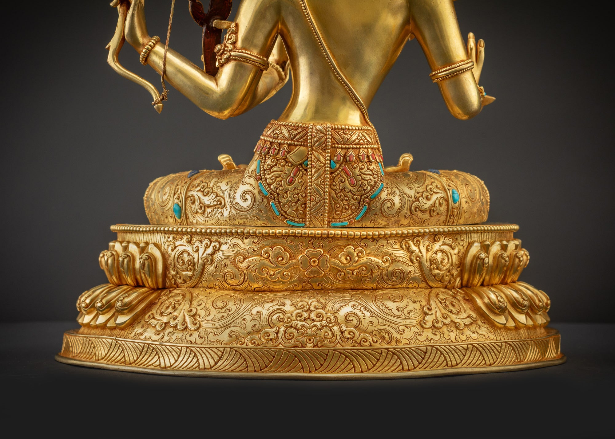 Detailed landscape shot back view of Maha Manjushri statue on lotus seat with glowing textures.
