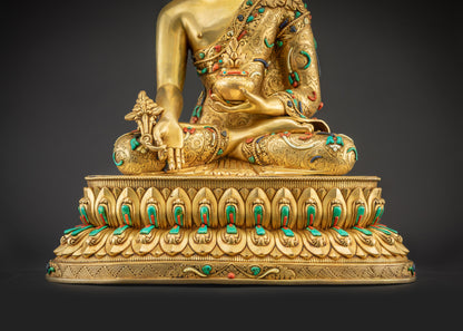 Detailed landscape shot front of Medicine Buddha seated on lotus showing full golden body
