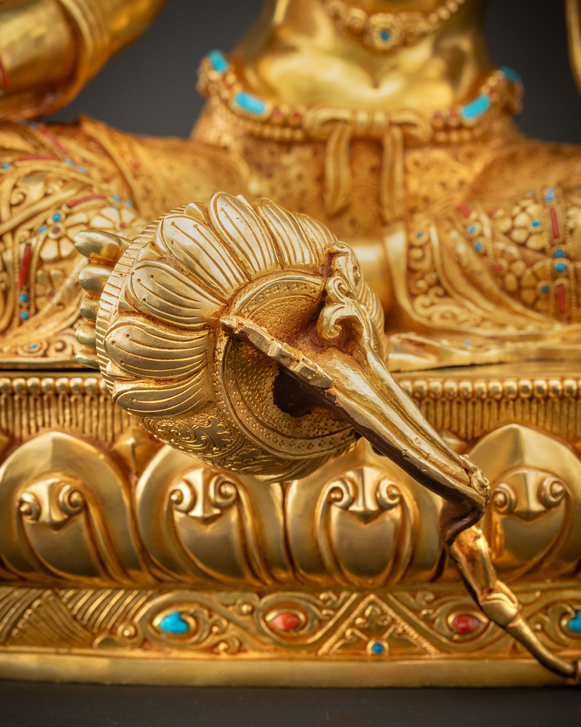 Detailed shot of blooming lotus seat beneath Green Tara with carved patterns
