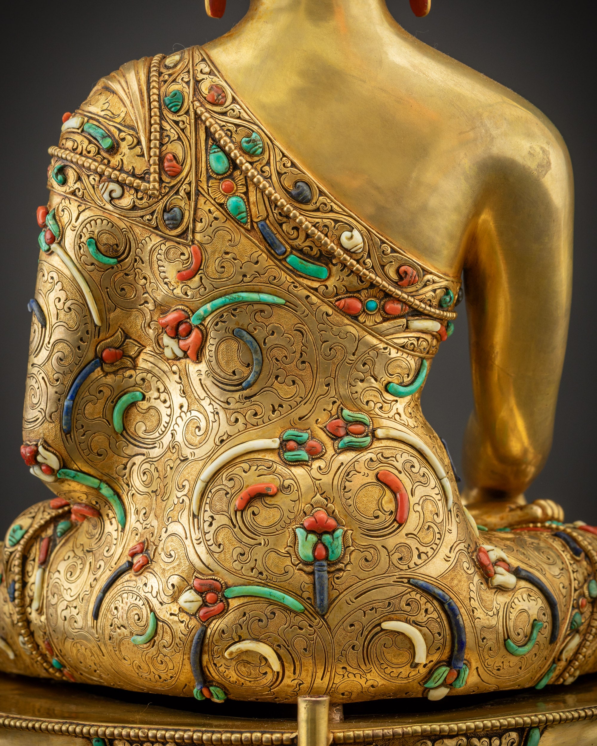 Detailed shot of robe and stones highlighting semi-precious gem inlays and golden contrast
