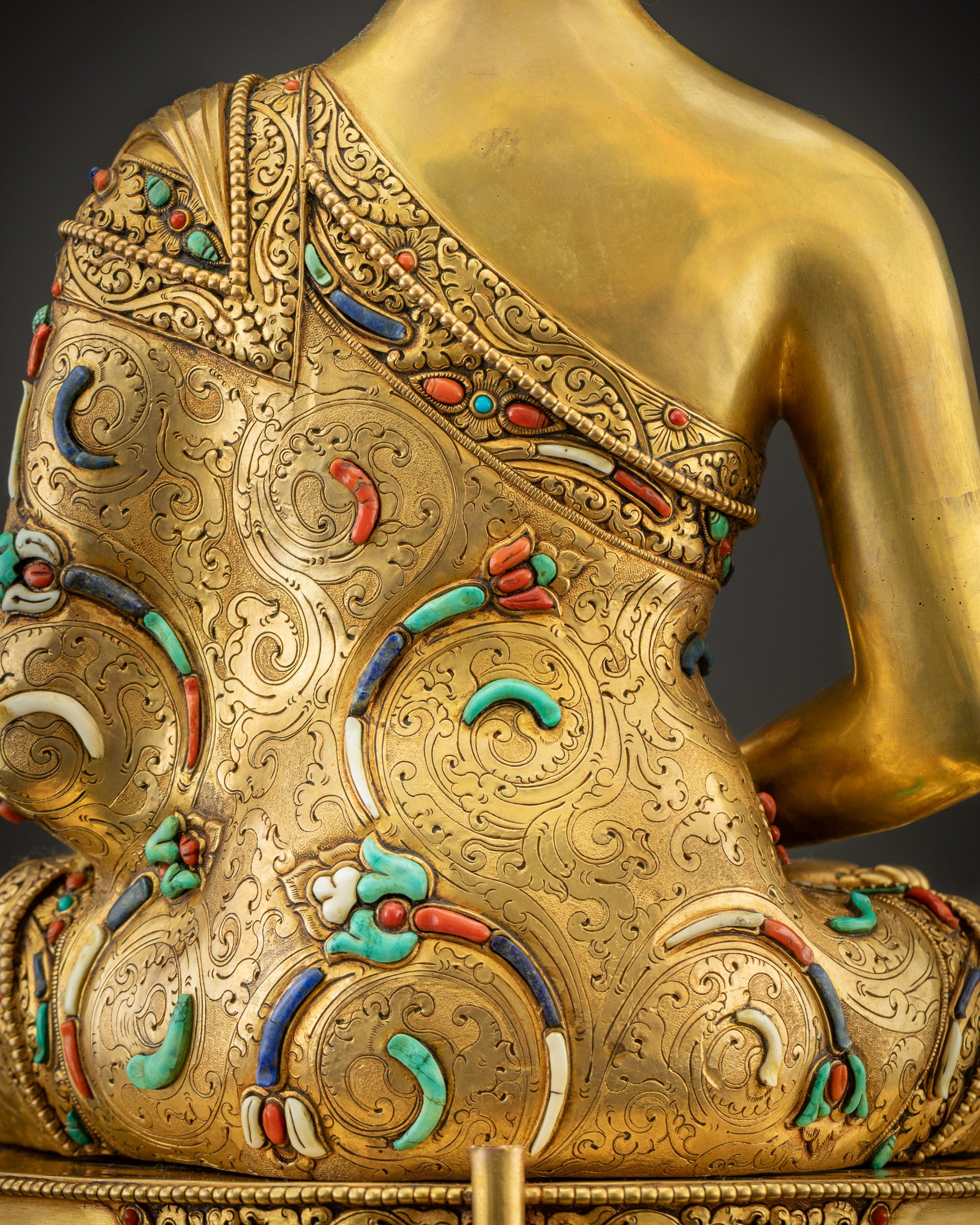 Detailed shot of robe and stones on Amitabha Buddha, floral motifs and gemstones
