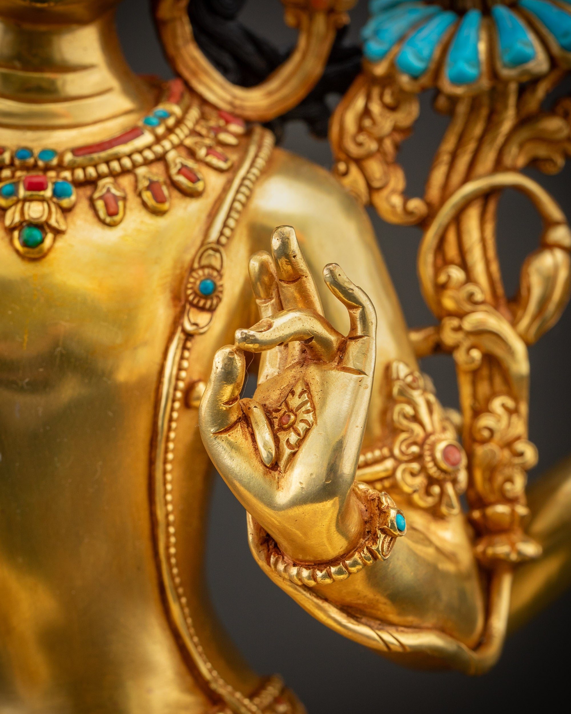 Detailed shot of robe on Maha Manjushri statue showing ornate carvings, gold, and semi-precious stones.
