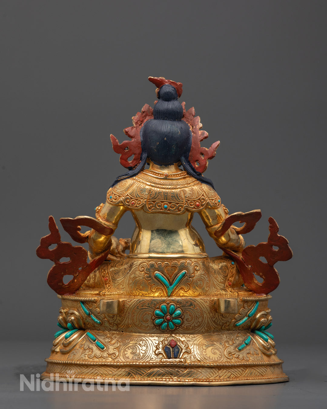 Detailed shot of vibrant semi-precious stones and ornate decorations on Dzambhala Statue