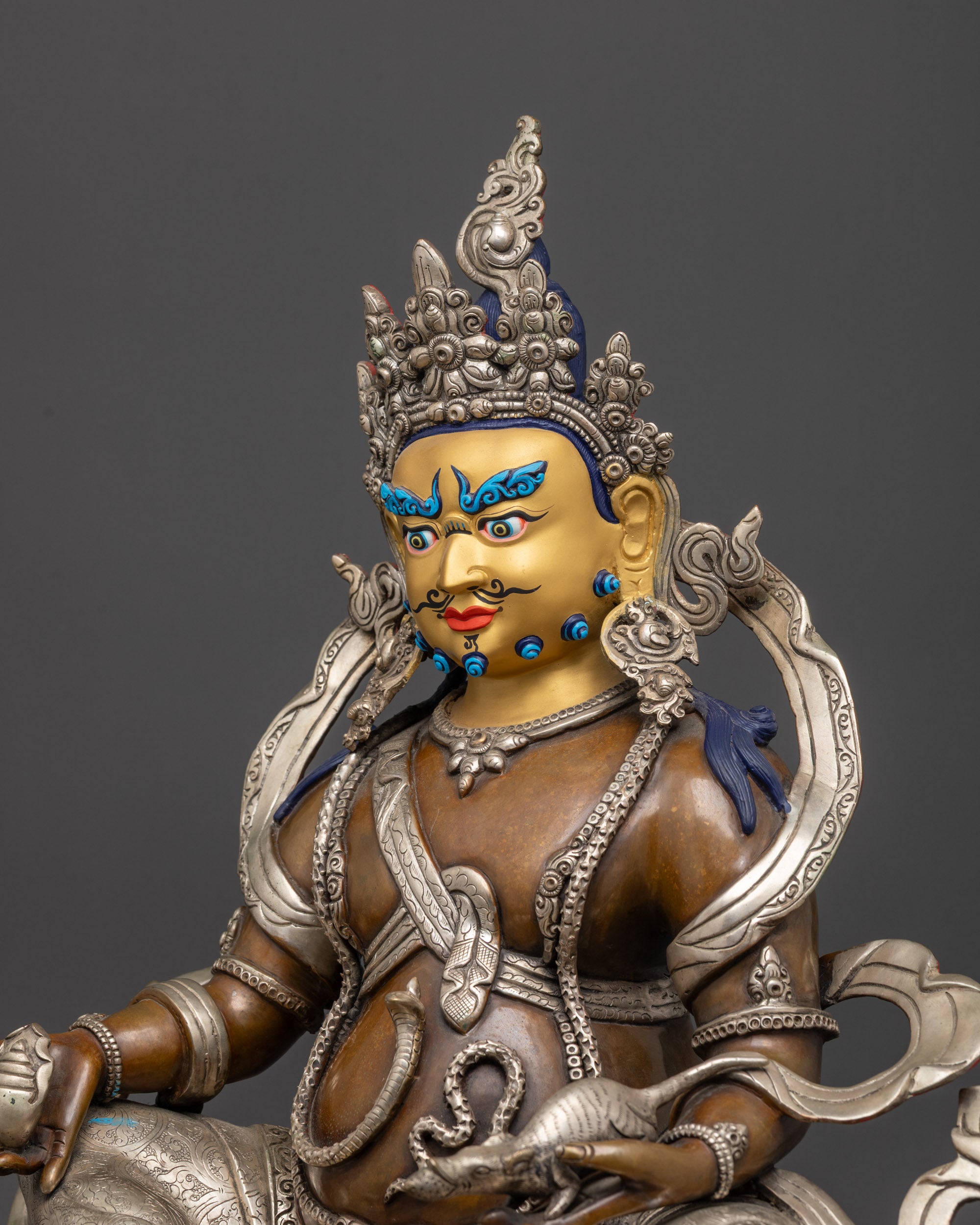 Detailed side Dzambhala statue showing silver-plated garments, intricate carvings, jewelry
