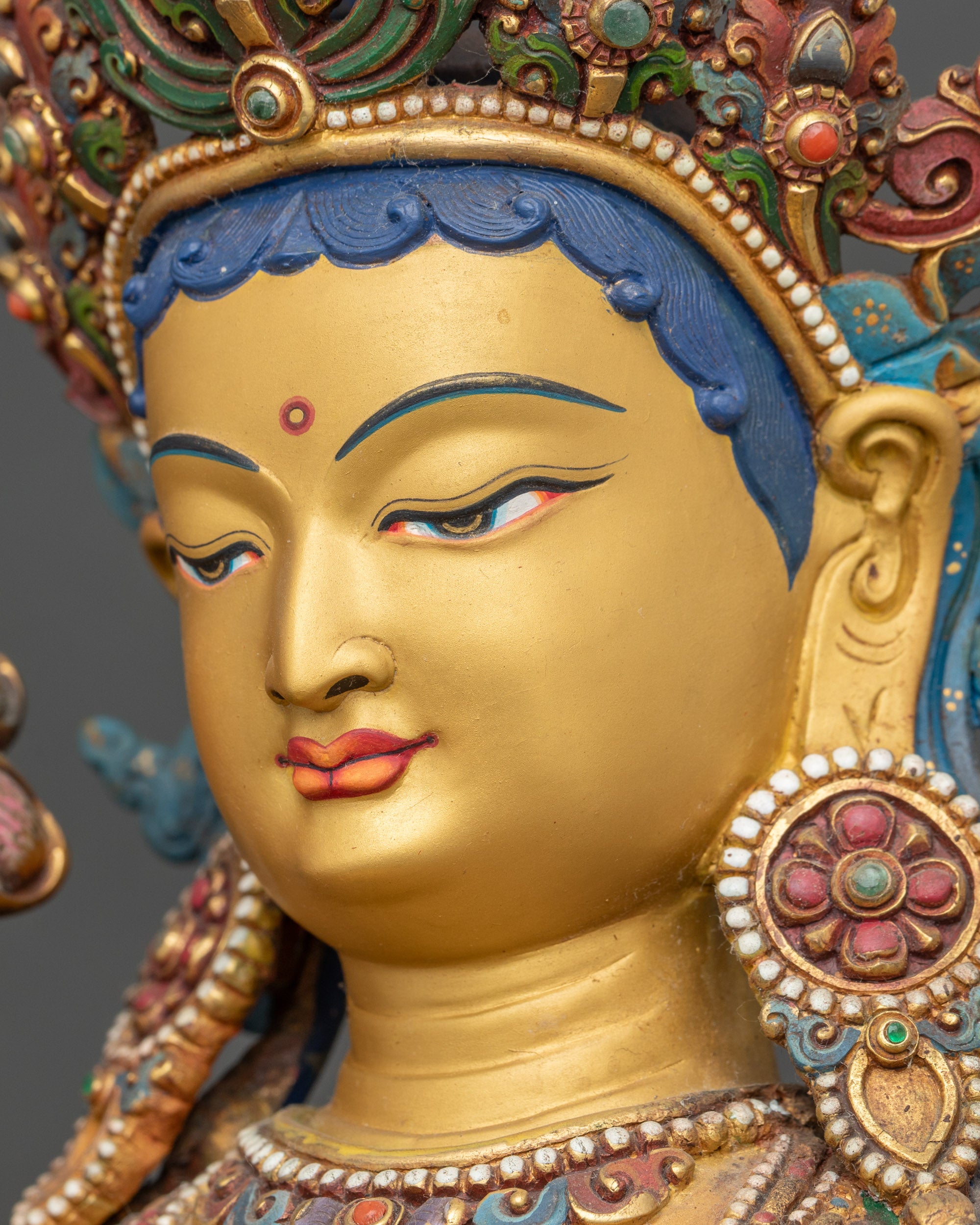 Detailed side close-up face of Green Tara showing tranquil expression and painted features