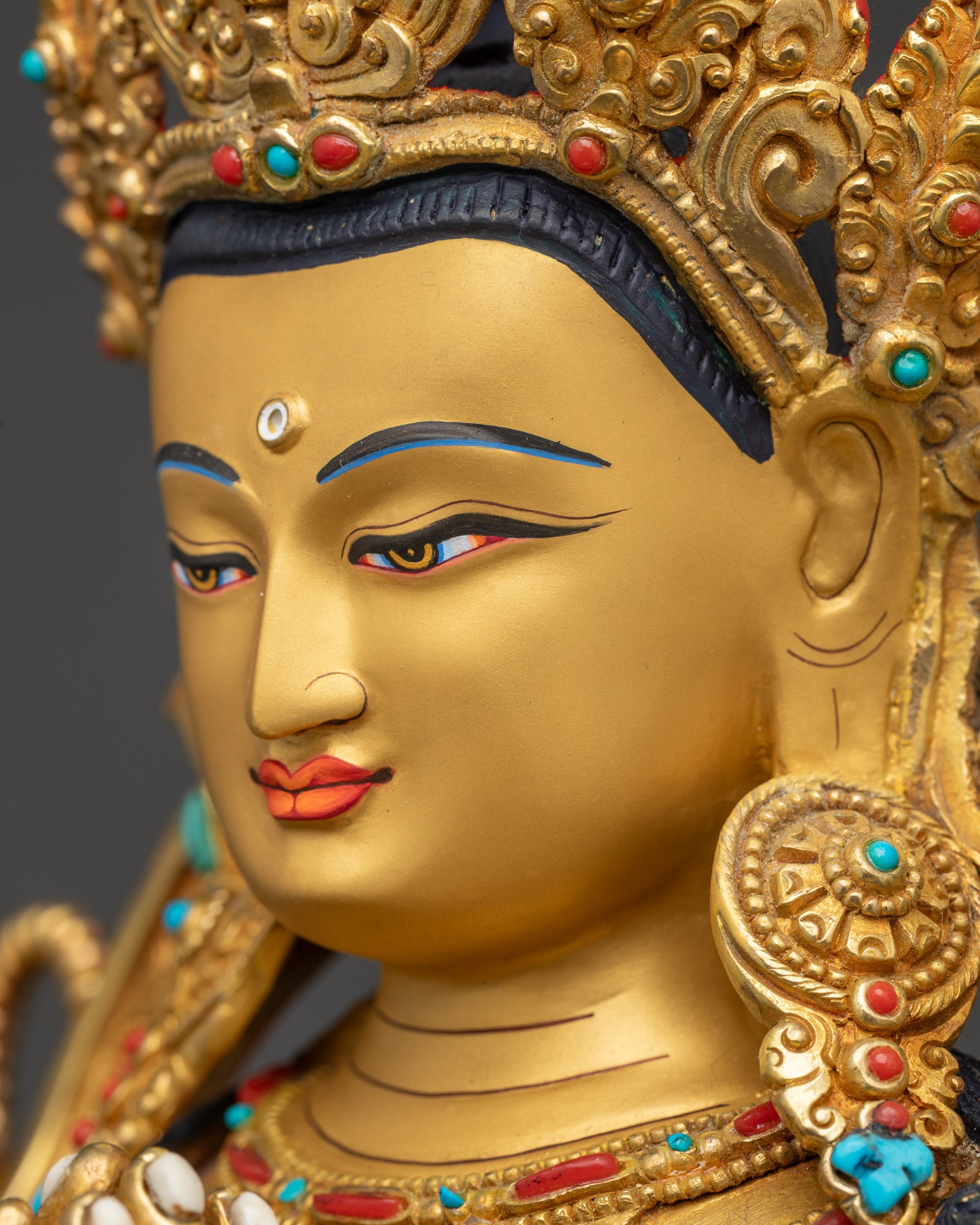 Detailed side close-up of Avalokiteshvara Chenrezig face with intricate crown and earrings