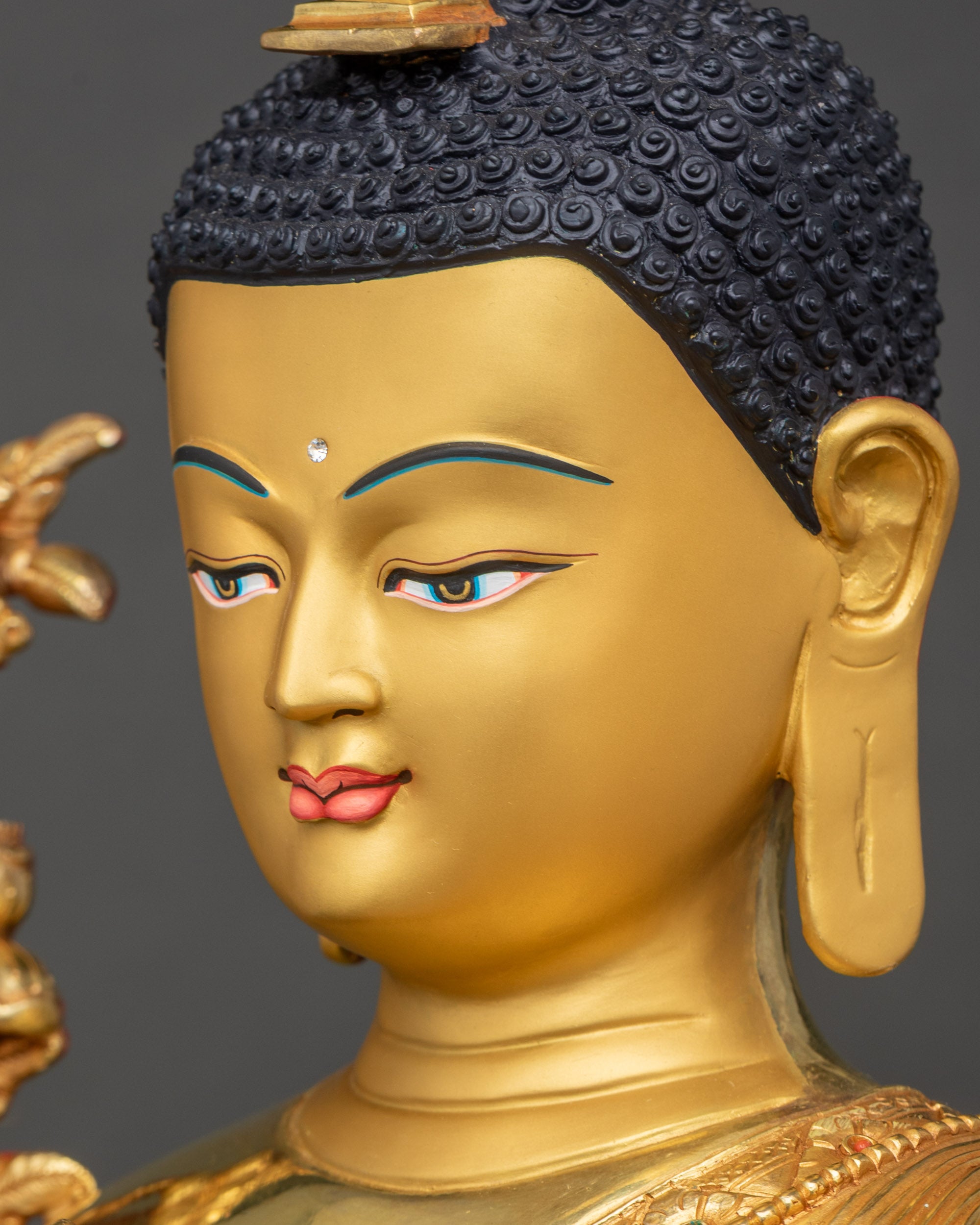 Detailed side close-up of Buddha’s face with tranquil gold-painted expression
