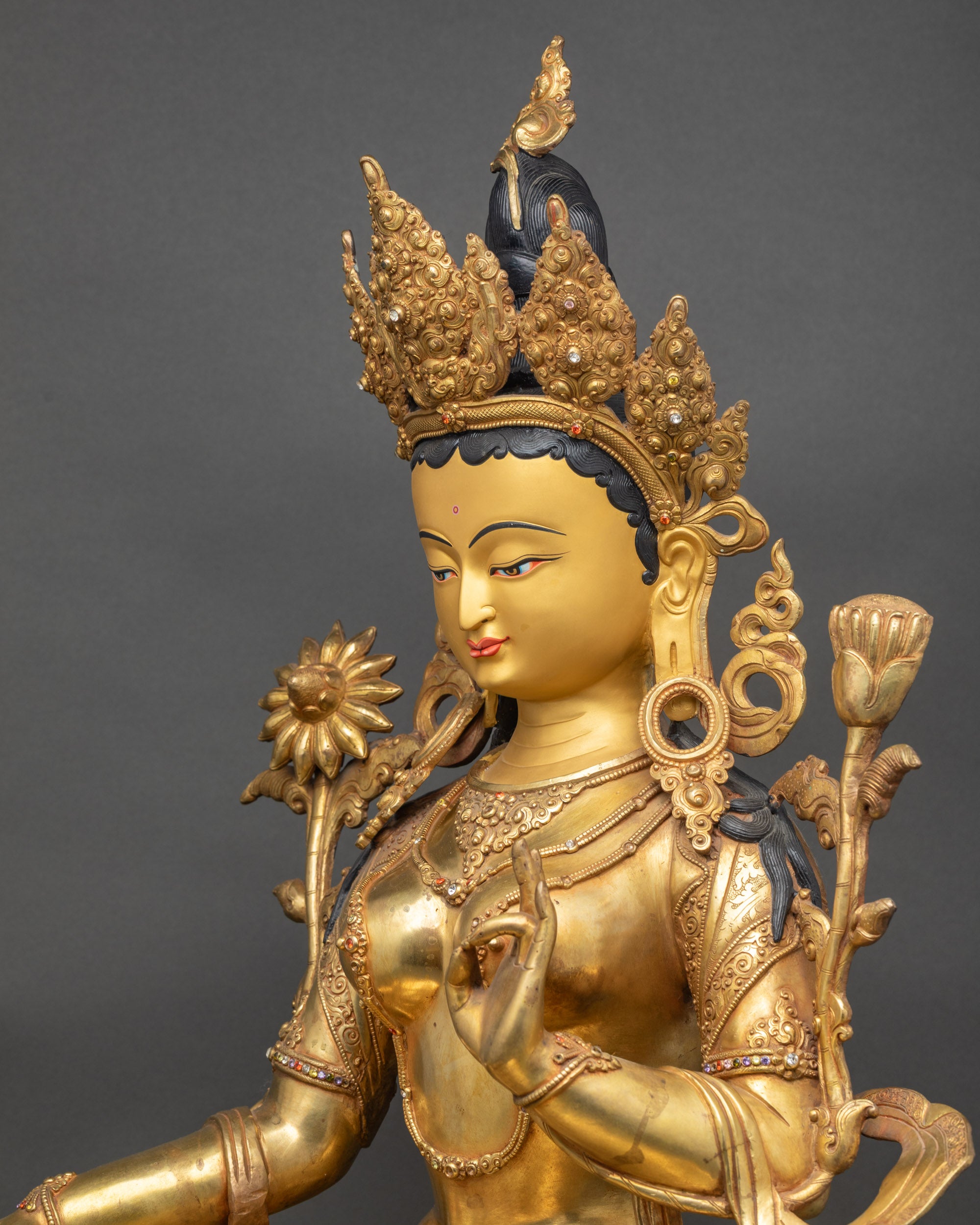 Detailed side close-up of Green Tara holding Utpala flower on lotus seat