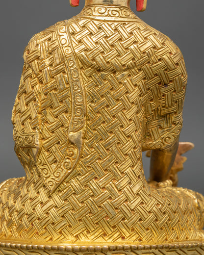 Detailed side close-up of Medicine Buddha statue, intricate gold fire-gilded garments visible
