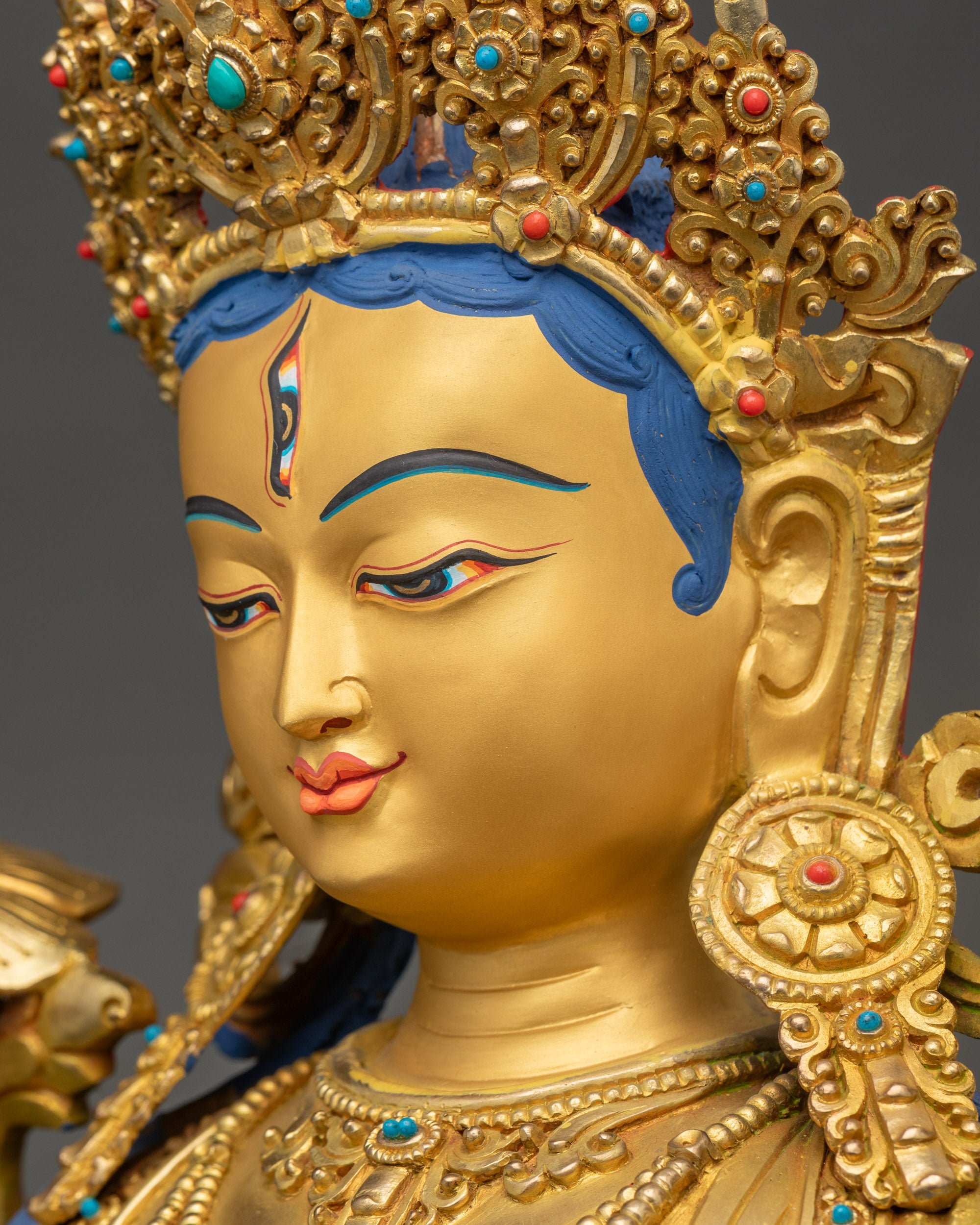 Detailed side close up face of White Tara sculpture showing crown work and compassionate gaze