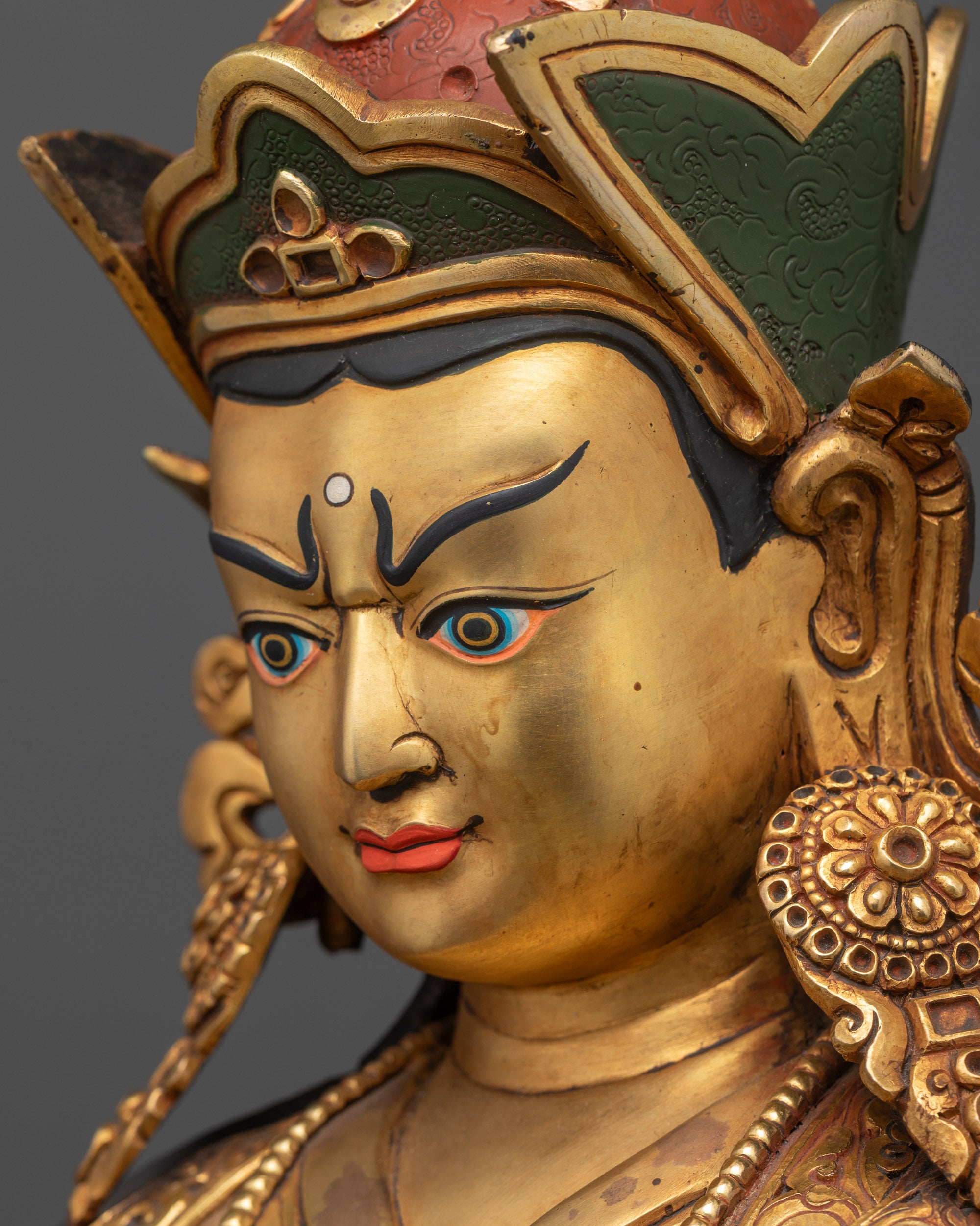 Detailed side close up of Guru Rinpoche face with upper and lower kasaya robes in rich acrylic colors