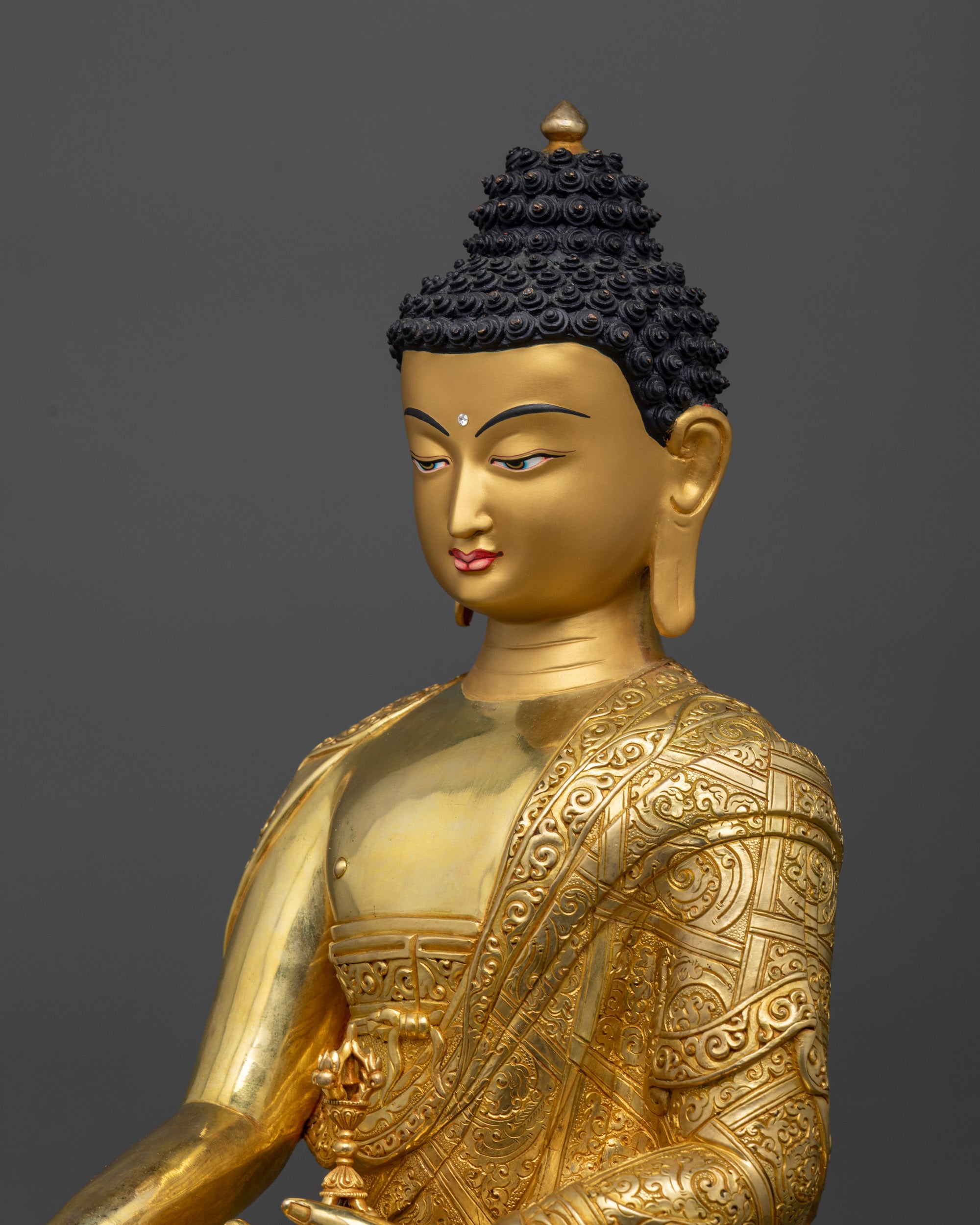 Detailed side close up of Mitrugpa Buddha statue showing intricately carved monk’s robe
