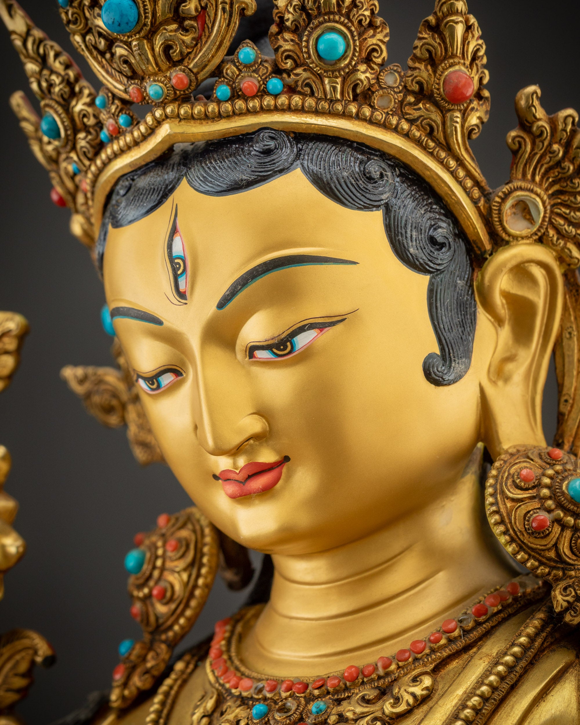 Detailed side close up of face White Tara serene expression gold-gilded seven-eyed face
