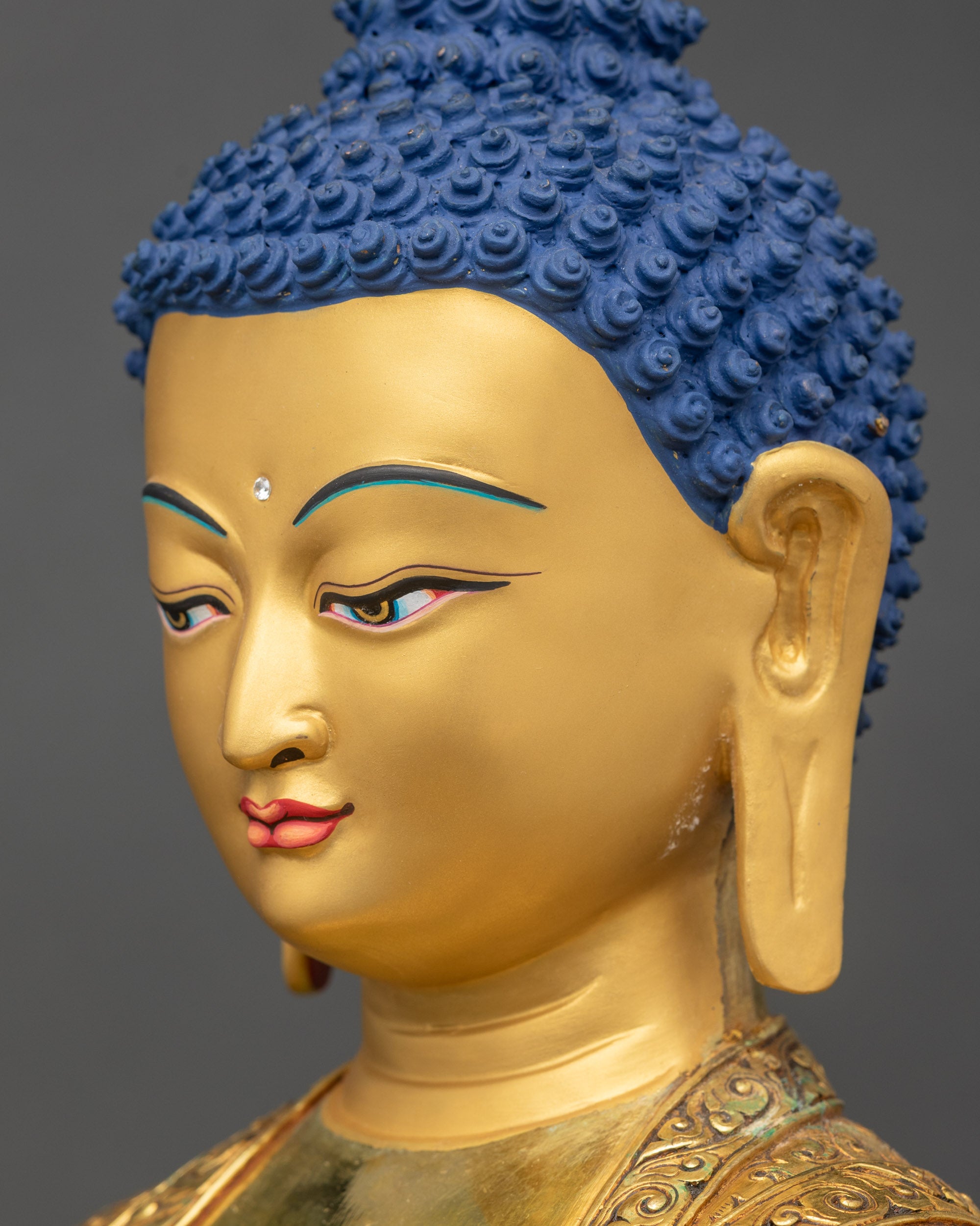 Detailed side close up of the face Side profile of gold fire gilded Amitabha Buddha with peaceful meditative gaze