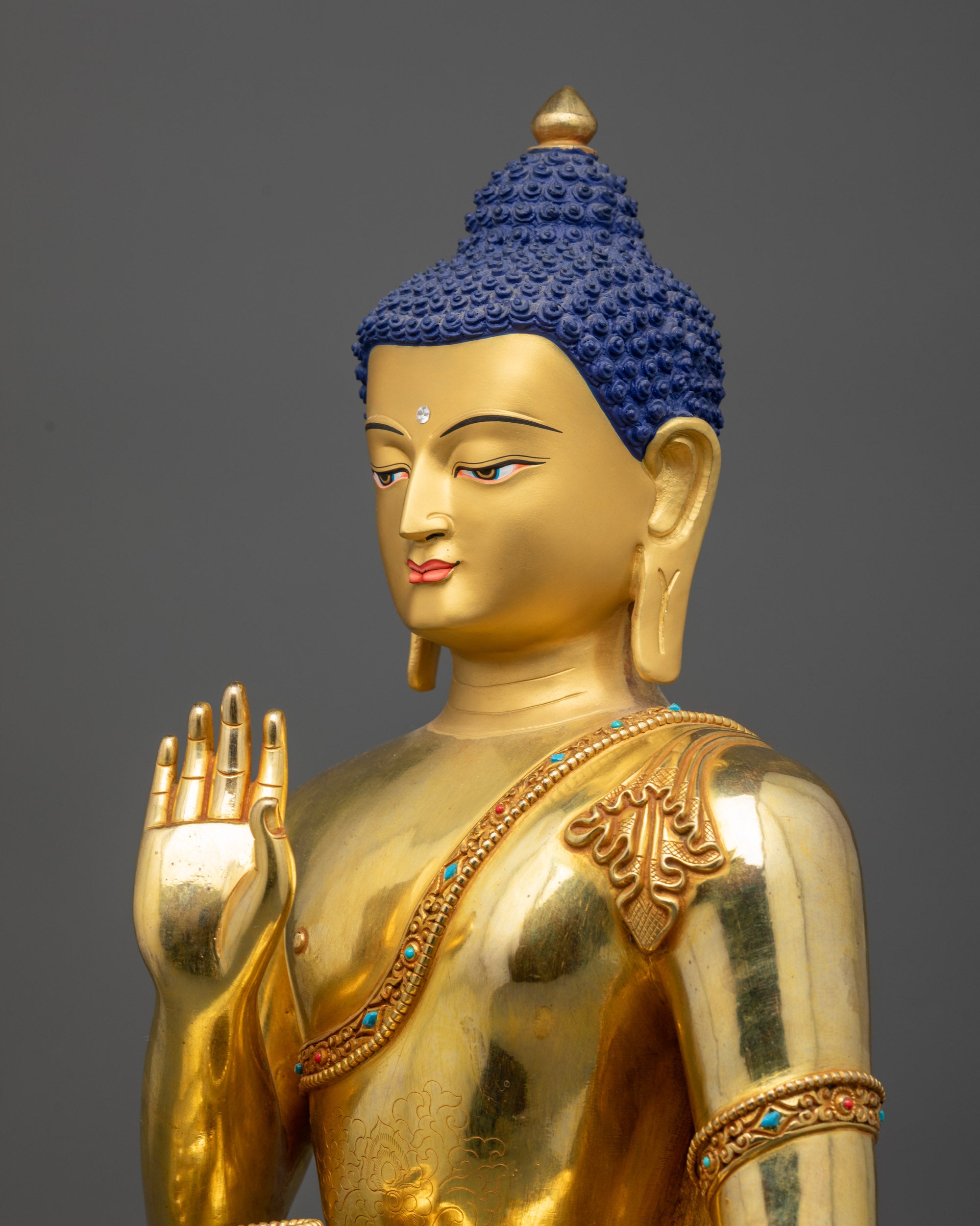 Detailed side view of Amoghasiddhi Buddha statue seated on lotus with gold-gilded face