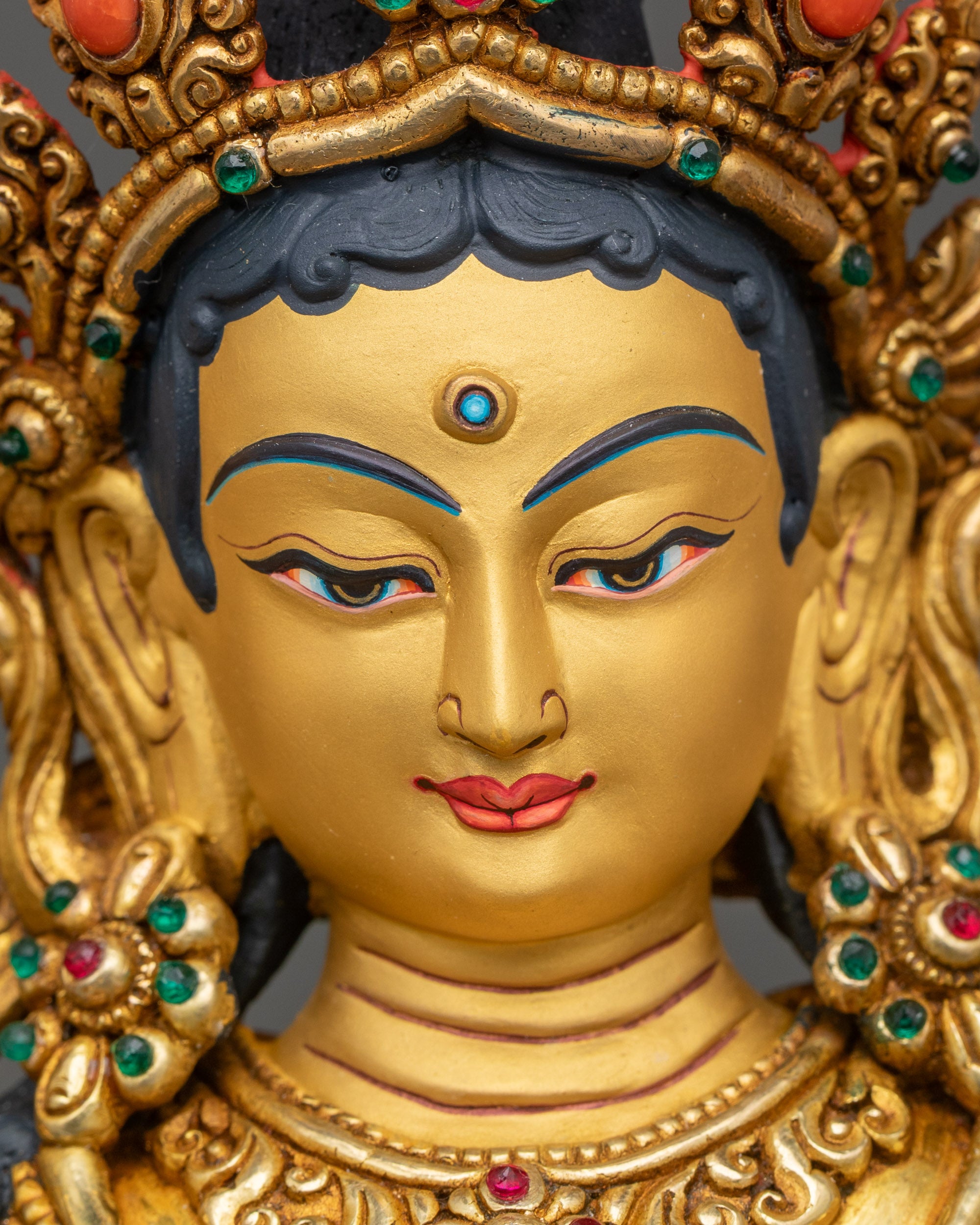 Detailed side view of Green Tara statue with carved robes and lotus seat