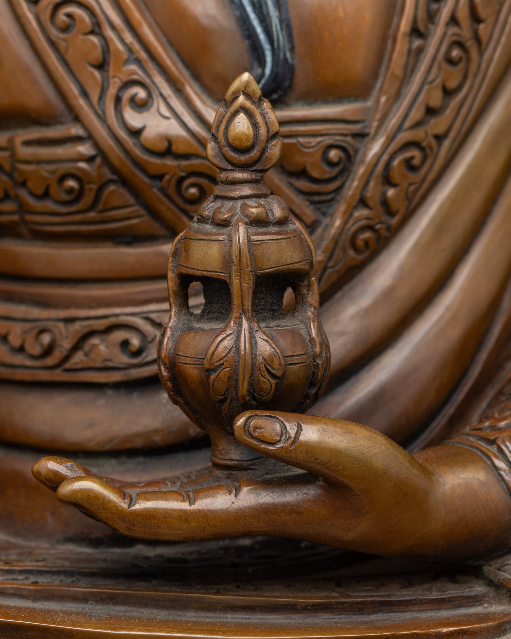 Detailed side view of Guru Shapdum Buddhist statue showing ritual objects and copper work
